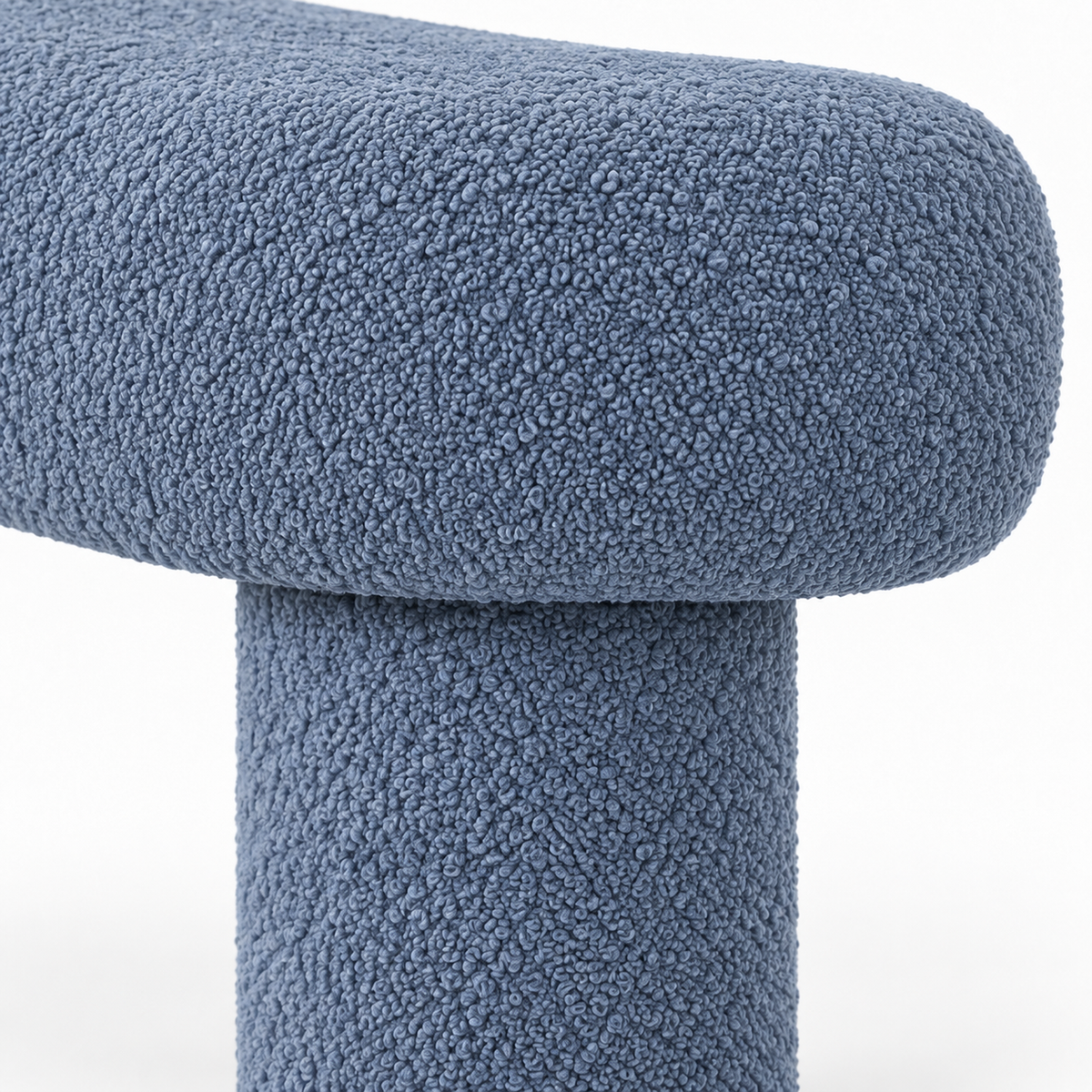 Close-up of slate blue boucle texture where the top meets a cylindrical leg on the Oru bench