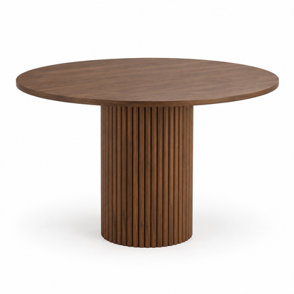 Orso round dining table in warm walnut with a fluted pedestal base, three-quarter view