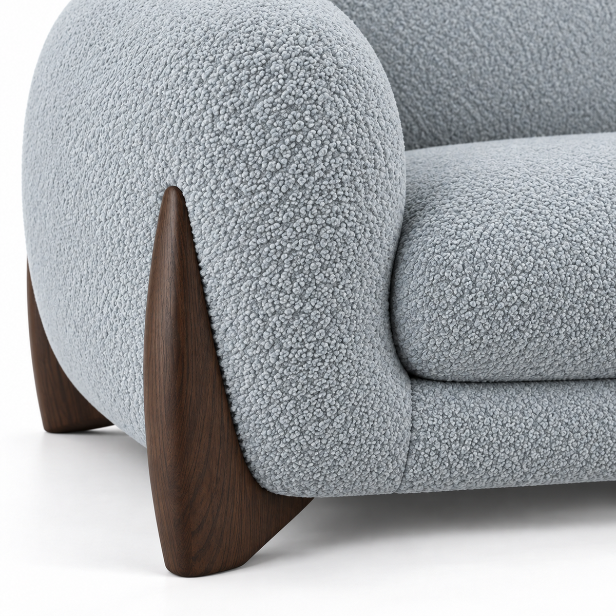 Close view of the curved smoked-oak wood accent sweeping up beside the rounded boucle arm on the Covo sofa
