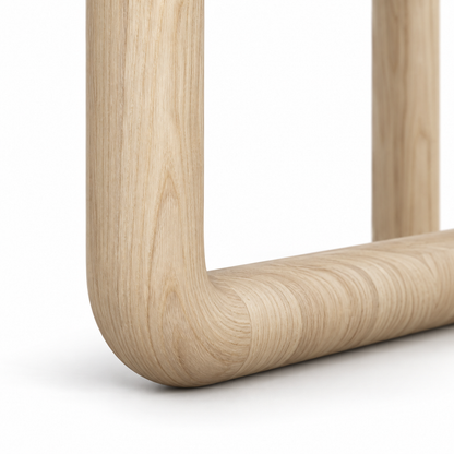 Close-up of the bent-tube corner and ash-blonde wood grain on the Dano dining table