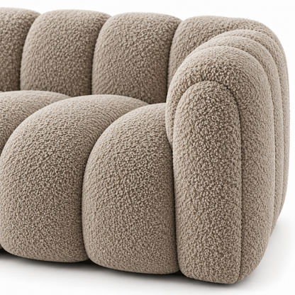 Close view of the deep channels and curly boucle texture on the rounded arm of the Sella sofa
