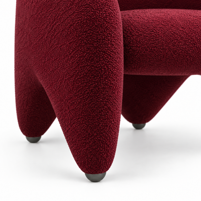Close-up of Faye armchair burgundy boucle texture on the sculptural front leg
