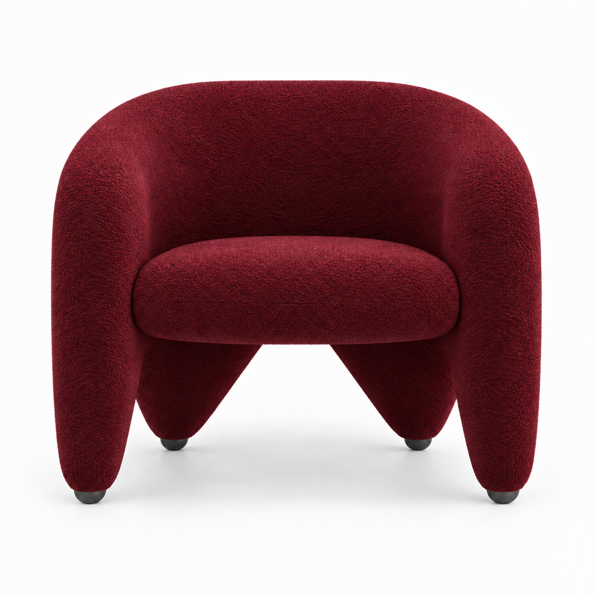 Faye armchair front view showing wrap-around shell and splayed sculptural legs in burgundy boucle
