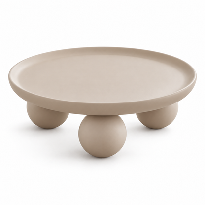 Bolo coffee table in soft clay-beige with a round tray top on three spherical feet, three-quarter view