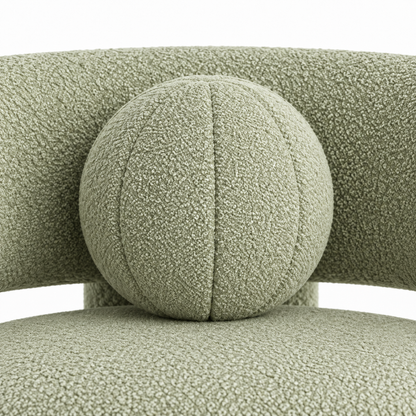 Close-up of Pomo armchair round toss pillow showing segmented stitching and boucle texture
