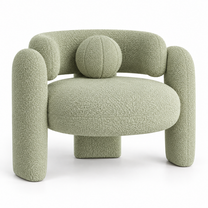 Pomo sculptural boucle armchair with round seat, crossing tube arms and round toss pillow in soft pistachio, three-quarter view