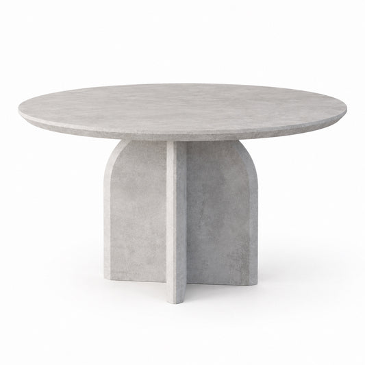 Qamar round dining table with stone-look top and crossed arch pedestal base, three-quarter view