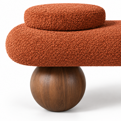Close-up of terracotta boucle texture meeting the walnut ball foot on the Kura bench
